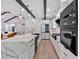 Modern kitchen features a marble countertops, stainless steel appliances, and exposed beams at 507 Karen Ln, Woodstock, GA 30188