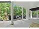 Covered patio with concrete flooring and multiple support columns overlooking the tree-lined yard at 507 Karen Ln, Woodstock, GA 30188