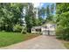 Traditional two-story home with a front porch, bay window, two-car garage, and green lawn with trees at 83 Andrew Jackson Ct, Dallas, GA 30157