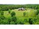 An aerial view captures the home nestled amid lush trees, expansive lawn and long driveway, creating a private oasis at 1101 N Flat Rock Rd, Douglasville, GA 30134