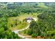 A high angle view showcases the estate's layout, surrounded by lush trees, landscaping, and a winding driveway at 1101 N Flat Rock Rd, Douglasville, GA 30134