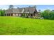 Lush green lawn around the rear of a two-story home featuring stone accents and a three-car garage at 1101 N Flat Rock Rd, Douglasville, GA 30134