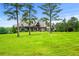 Sprawling lawn and mature trees frame this charming, stone-accented, two-story home under a bright blue sky at 1101 N Flat Rock Rd, Douglasville, GA 30134