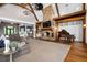 Open living room with a stone fireplace, beamed ceilings, and a large sectional couch at 1101 N Flat Rock Rd, Douglasville, GA 30134