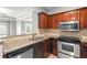 Modern kitchen featuring granite countertops, stainless steel appliances, and wood cabinets at 1502 River Green Nw Dr # 1502, Atlanta, GA 30327