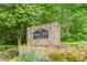 Stone monument sign for The River West Condominium with colorful landscaping and green trees at 1502 River Green Nw Dr # 1502, Atlanta, GA 30327