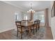 Elegant dining room with a large wood table, stylish chandelier, and natural light creating a welcoming ambiance at 319 Parkside Meadow Dr, Marietta, GA 30064