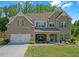 Charming brick two-story home featuring a well-manicured lawn, covered entryway, and attached two-car garage at 319 Parkside Meadow Dr, Marietta, GA 30064