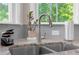 Close-up of a kitchen sink with a modern faucet, granite countertop, and a view to the outside at 319 Parkside Meadow Dr, Marietta, GA 30064
