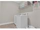 Laundry room with stacked washer and dryer, shelving, and tile flooring at 319 Parkside Meadow Dr, Marietta, GA 30064