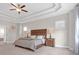 Spacious main bedroom with a tray ceiling, ceiling fan, and plush carpet at 319 Parkside Meadow Dr, Marietta, GA 30064