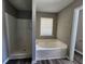 This bathroom features a shower and a soaking tub near a bright window at 4510 Swan Trce, Atlanta, GA 30349