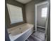 Bathroom features a large soaking tub with a bright window and wood-look flooring at 4510 Swan Trce, Atlanta, GA 30349