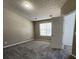 This bedroom features neutral carpeting and a large window that brings in natural light at 4510 Swan Trce, Atlanta, GA 30349
