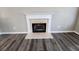 Close-up of fireplace with white mantel and light-colored stone hearth and surround on dark floors at 4510 Swan Trce, Atlanta, GA 30349
