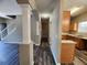 Hallway featuring dark modern floors, neutral paint, and arched column to the kitchen and stairs at 4510 Swan Trce, Atlanta, GA 30349
