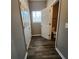 Hallway features wood-look flooring, access to a closet, and a powder room with a window at 4510 Swan Trce, Atlanta, GA 30349