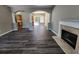 Elegant living room featuring fireplace, dark wood floors, arched doorways to kitchen and dining at 4510 Swan Trce, Atlanta, GA 30349