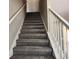 Carpeted staircase with white railing leads to the upper level of the home at 4510 Swan Trce, Atlanta, GA 30349
