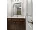 Bathroom vanity with a marble countertop and wood cabinetry, featuring a mirror and vanity lighting at 605 Parkaire Xing, Marietta, GA 30068