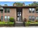 Inviting condo exterior featuring well-maintained landscaping and a two-story entrance with natural wood siding at 605 Parkaire Xing, Marietta, GA 30068