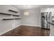 Bright eat-in kitchen with stainless steel appliances, floating shelves, and hardwood flooring at 605 Parkaire Xing, Marietta, GA 30068