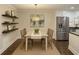 Eat-in kitchen with a table, chairs, stainless steel appliances, floating shelves and hardwood flooring at 605 Parkaire Xing, Marietta, GA 30068