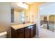 Bathroom vanity with granite countertop, dark wood cabinets, and an open doorway at 335 Roberts Run Cv, Suwanee, GA 30024
