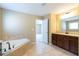 Well lit bathroom featuring a soaking tub, double vanity and tile floors, perfect for relaxing and pampering at 335 Roberts Run Cv, Suwanee, GA 30024