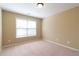 Empty bedroom with neutral walls and a window providing natural light at 335 Roberts Run Cv, Suwanee, GA 30024