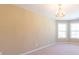 Sun-filled bedroom showcases a decorative chandelier, neutral walls, and bay windows for a light and airy feel at 335 Roberts Run Cv, Suwanee, GA 30024