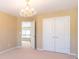 This bedroom features a chandelier, light walls, a closet and a doorway to another room at 335 Roberts Run Cv, Suwanee, GA 30024