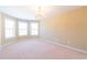 Bright bedroom boasts a chandelier, natural light from bay windows, and neutral walls for a calm and relaxing space at 335 Roberts Run Cv, Suwanee, GA 30024