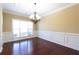 Elegant dining room showcases hardwood floors, wainscoting, and a chandelier at 335 Roberts Run Cv, Suwanee, GA 30024