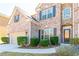 Close-up of a brick home showcasing a well-kept lawn, decorative bushes, and inviting front door at 335 Roberts Run Cv, Suwanee, GA 30024