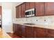 Kitchen with stainless microwave, gas range, granite countertops, and dark wood cabinets at 335 Roberts Run Cv, Suwanee, GA 30024