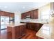 Kitchen featuring stainless appliances, island with granite countertops, and dark wood cabinets at 335 Roberts Run Cv, Suwanee, GA 30024
