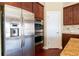 Kitchen featuring stainless steel refrigerator, built-in oven, dark wood cabinets, and granite countertops at 335 Roberts Run Cv, Suwanee, GA 30024