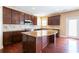 Well-lit kitchen featuring dark wood cabinetry, granite countertops, and a large island at 335 Roberts Run Cv, Suwanee, GA 30024