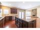Spacious kitchen with dark wood cabinets, granite island, stainless appliances and open layout at 335 Roberts Run Cv, Suwanee, GA 30024