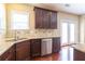 Kitchen sink, granite countertops, stainless dishwasher, and dark wood cabinetry at 335 Roberts Run Cv, Suwanee, GA 30024
