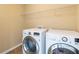 Modern laundry room with white washer and dryer at 335 Roberts Run Cv, Suwanee, GA 30024