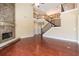 Living room with hardwood floors, stone fireplace, and staircase with iron balusters at 335 Roberts Run Cv, Suwanee, GA 30024