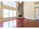Open living space with tall windows, hardwood floors, and a stone fireplace as a focal point at 335 Roberts Run Cv, Suwanee, GA 30024