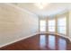 Bright living room featuring hardwood floors, a shiplap accent wall, and large windows at 335 Roberts Run Cv, Suwanee, GA 30024