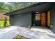 Contemporary home entrance featuring brick, a wooden door, and landscaped walkway at 3964 Gretna Green Dr, Decatur, GA 30035