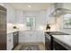 Bright kitchen with white cabinets, stainless steel appliances, and modern finishes at 605 Patrick Ne Pl, Sandy Springs, GA 30328
