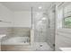 Bright bathroom with soaking tub and glass shower featuring white and gray tones at 655 Mead Se St # 58, Atlanta, GA 30312