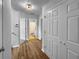 View of a hallway featuring wood-look floors, neutral paint and trim, with multiple doors and closets at 902 Ashton Oak Cir, Stone Mountain, GA 30083