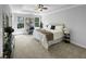 Serene main bedroom features a tray ceiling, soft carpet, and large windows that enhance the room's tranquility at 902 Ashton Oak Cir, Stone Mountain, GA 30083